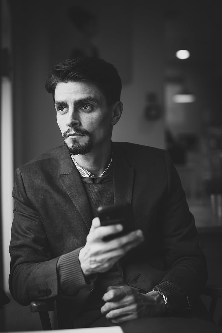 black-and-white, man, person, serious, smartphone, texting, thinking
