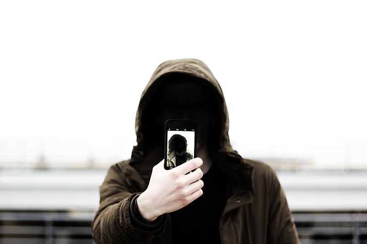 man, brown, hoodie, jacket, standing, holding, phone
