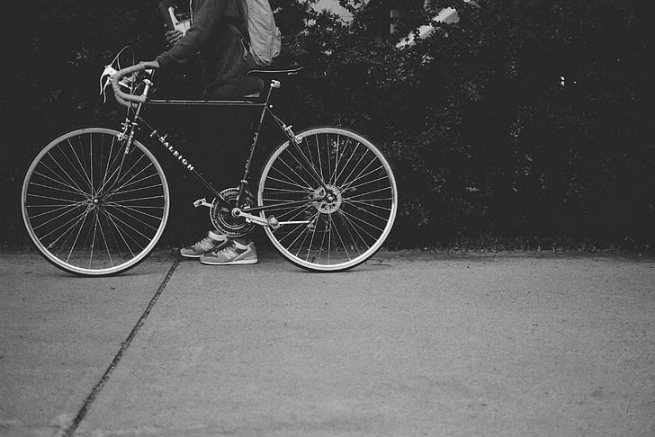 bicycle, bike, black-and-white, cyclist, pavement, person, street