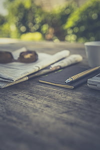 macro, newspaper, notebook, pen, table