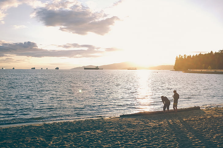 man, woman, standing, near, ocean, sunset, beach