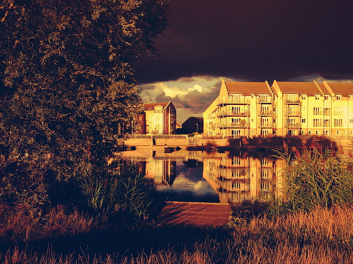 buildings, clouds, houses, reflection, sepia, trees, water