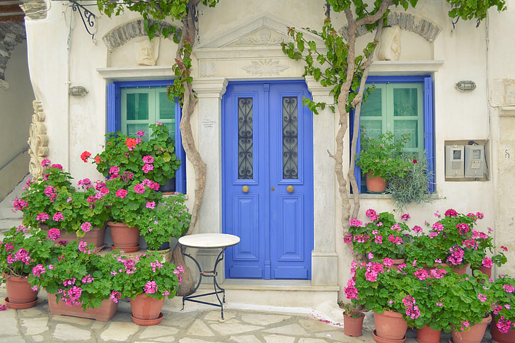 griechische Insel Tür, Tinos Insel pyrgos, Dor mit Blumen, Windows, traditionelle Tiniotic Haus, Haus mit Blumen im Vordergrund, Haus mit Tisch vor