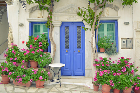 grekiska ön dörr, Tinos island pyrgos, dor med blommor, Windows, traditionella tiniotic hus, hus med blommor framför, hus med bord framför