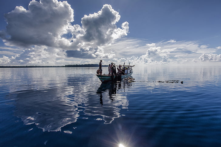 reflectie van het oppervlak van het water, landschap, boot, vissen vangen, Indonesië, Halmahera, Widi eilanden