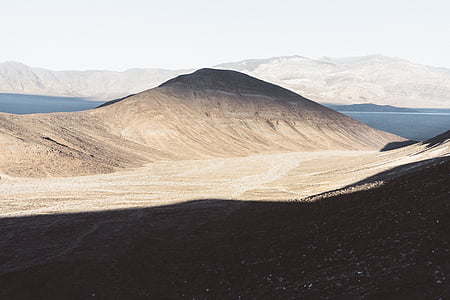 marrón, arena, montaña, cerca de, Océano, durante el día, paisaje