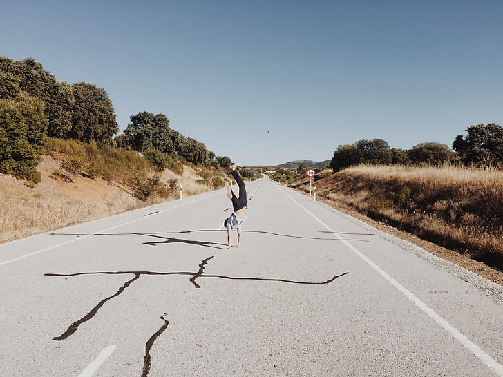handstand, man, person, road, sky, trees