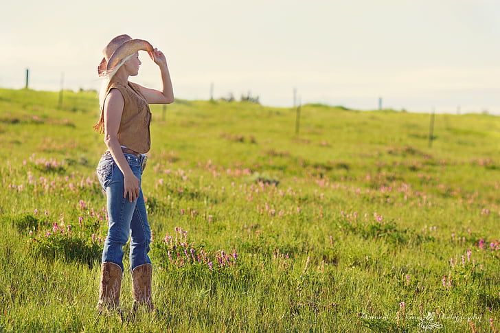 standing, tall, green, grass, holding, cowgirl, hat