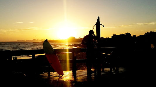 silueta, hombre, al lado de, barandilla de la, de surf, tablero, puesta de sol