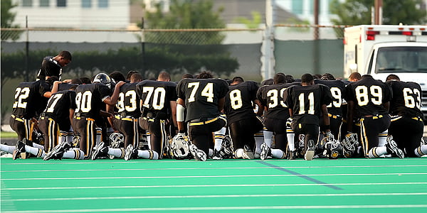 football team, praying, kneeling, team, football field, sport, game