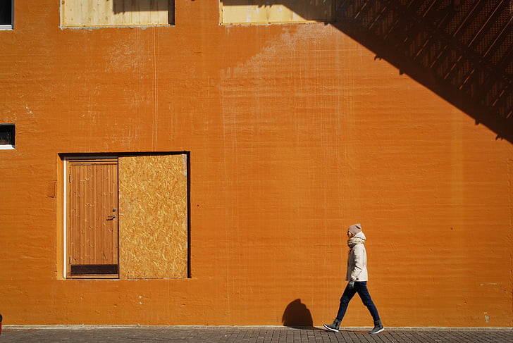 man, walking, beside, orange, building, girl, person