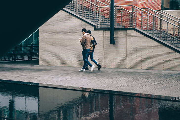 two, men, walking, holding, phones, architecture, building