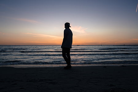 silueta, băiat, în picioare, ţărmul mării, plajă, apus de soare, orizont