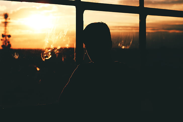 silhouette, homme, près de :, verre, fenêtre de, volet, coucher de soleil