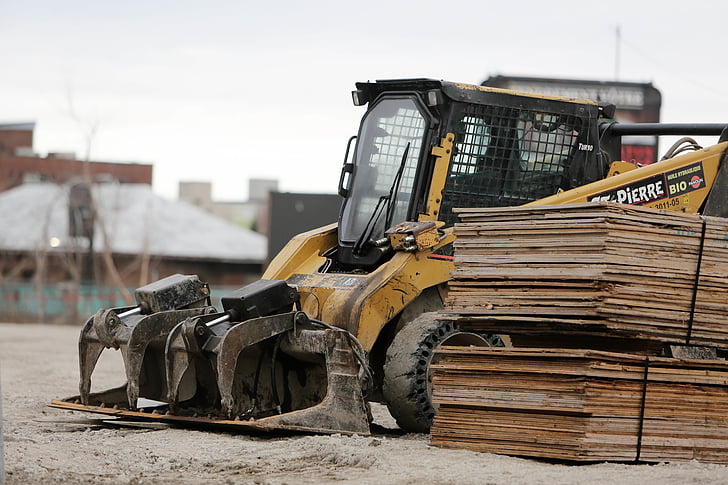 steer, skid, parked, next, pile, plyboards, construction