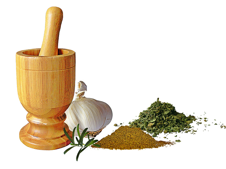 mortar, spices, head of garlic, cumin, oregano