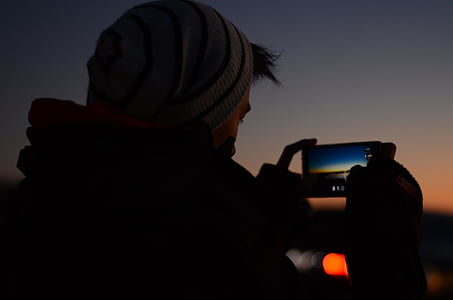 portrait, man, holding, smartphone, taking, photo, sunset