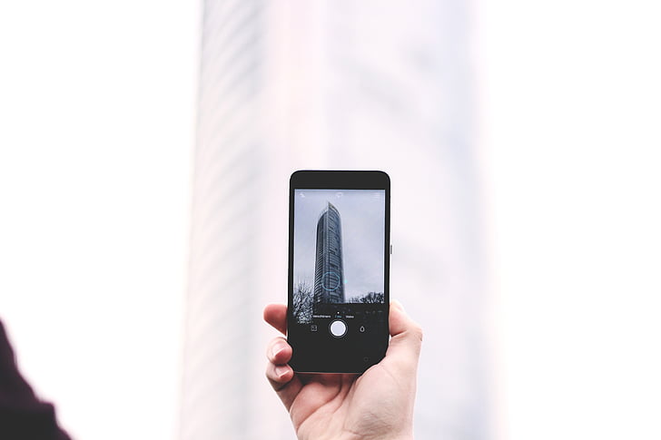 person, holding, iphone, phone, taking, photo, building