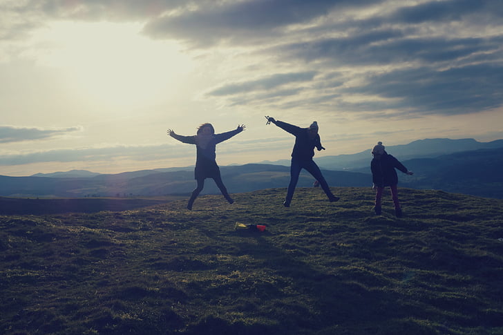 three, person, jumping, daytime, highland, mountain, valley