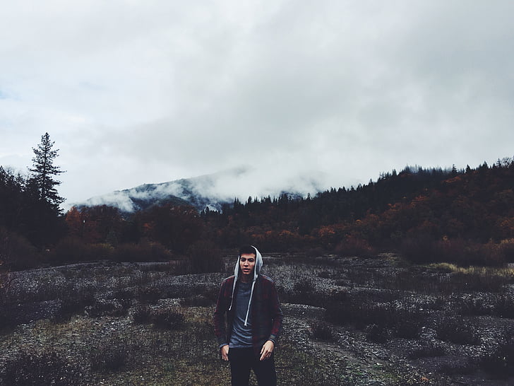 man, brown, white, hoodie, standing, outdoor, cloudy