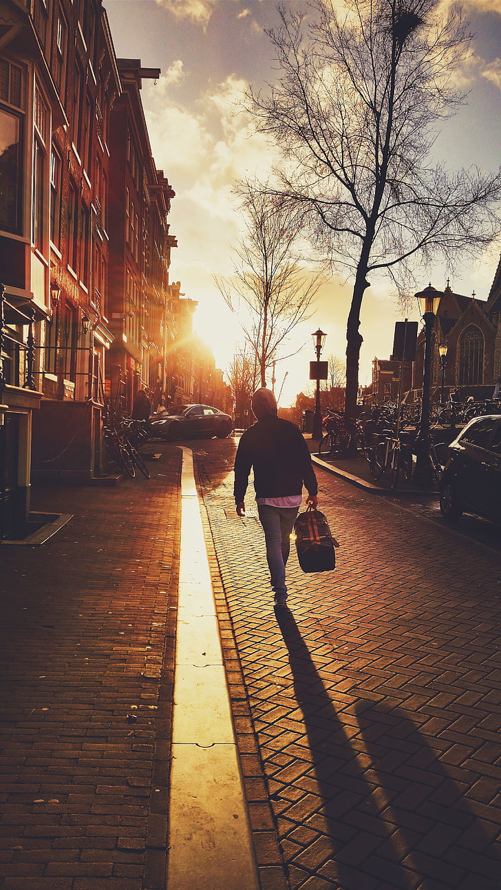 man, black, hoodie, walking, street, sunset, cobblestone