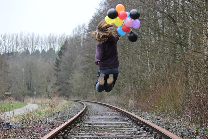 Момиче, железопътни релси, балони, природата, скок