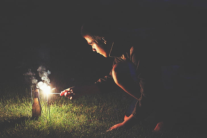 bottle, boy, firecrackers, grass, person, smoke, sparkler