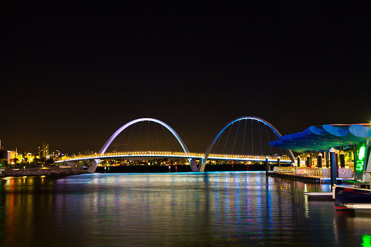 lightened, bridge, near, green, painted, building, nighttime