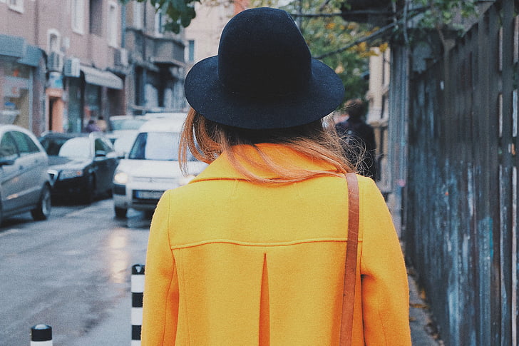 woman, orange, jacket, black, hat, walking, street