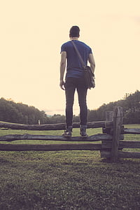 man, standing, wood, plank, fence, facing, grassland