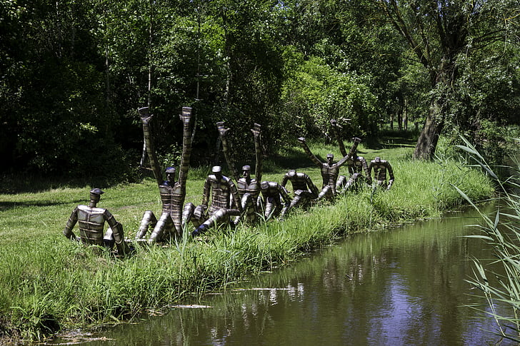 airētājiem, tērauda grupa skulptūra, tēlnieks Roberts ūdeņos, koki, zāle, ūdens pusē, saules