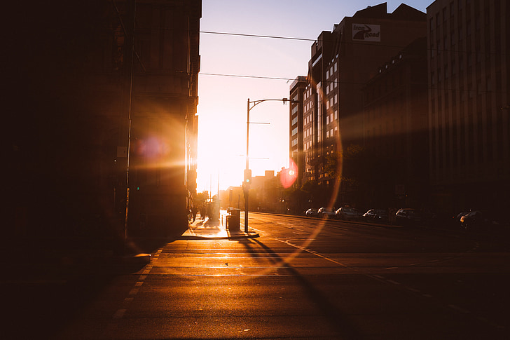 sunset, sun rays, intersection, city, streets, roads, buildings